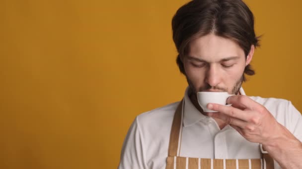 若い魅力的なバリスタコーヒーを飲むと喜んで脇に見ての肖像画カラフルな背景にコピースペース — ストック動画