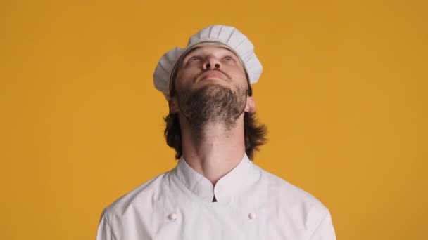 迷人的穿着制服的专业厨师惊奇地看着镜头 在五彩斑斓的背景上 露出仰视的姿态 哇表达 — 图库视频影像