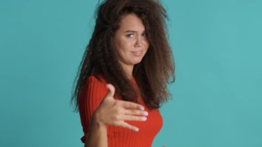 Kırmızı elbiseli üzgün esmer kız renkli arka planda reddedilme hareketi gösteriyor. Hayır, bu ilginç bir ifade değil.