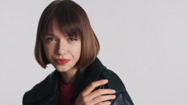 Kısa saçlı, kendine güvenen ve kameraya bakan güzel bir moda kızı. Stüdyoda şehvetli bir şekilde poz veren profesyonel model.