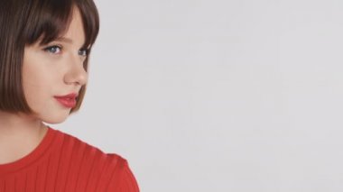 Kısa saçlı, kırmızı dudaklı, beyaz arka planda gülümseyen, reklam ya da tanıtım metni için yeri olan güzel esmer kızın kavramsal çekimini kapat.