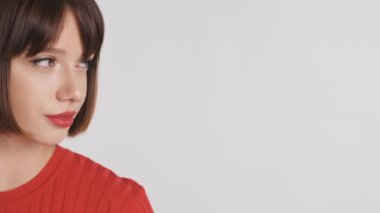Kırmızı dudaklı çekici esmer kız reklam veya tanıtım metni için kendine güveniyor ve beyaz arka planda gülümsüyor. Boşluk konseptini kopyala