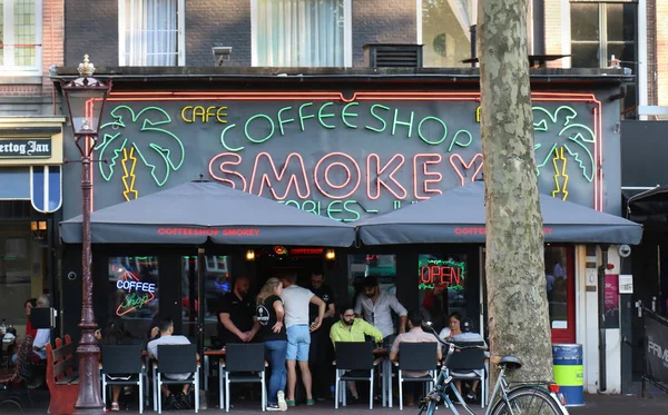 アムステルダム オランダ 2018 の少量の個人消費のためのインド大麻の販売が認可されたコーヒー ショップで許可されてしの地方自治体によって容認されてアムステルダムでスモーキー コーヒー ショップの前でリラックス — ストック写真