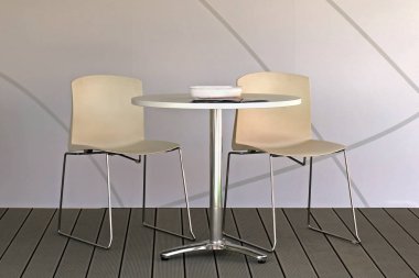 Ahşap zemin üzerinde iki sandalye ile modern tasarım masası