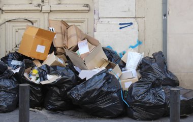 Büyük siyah plastik torbalar ve bunun dışında sokak kaldırım çöp yığını