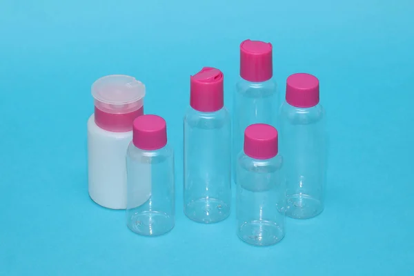 Pusty Zestaw Kosmetyków Podróży Butelki Pokrywką Różowy Niebieskim Tle — Zdjęcie stockowe
