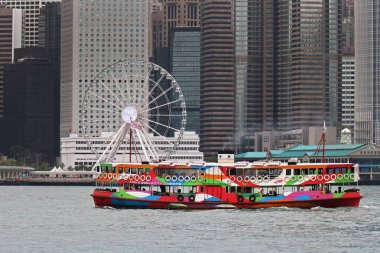 Hong Kong, Çin - 27 Nisan 2017: Star Feribotu'na Hong Kong yolcular arasında Victoria Harbour Island Sahil arka planda bulanık gökdelenler ile taşır. Star Feribotu'na bir yolcu feribot servisi operatör ve turistik Ho olduğunu