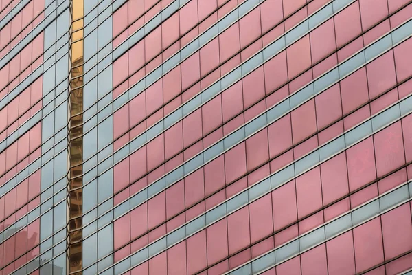 Modern building pink glass facade with light city reflections