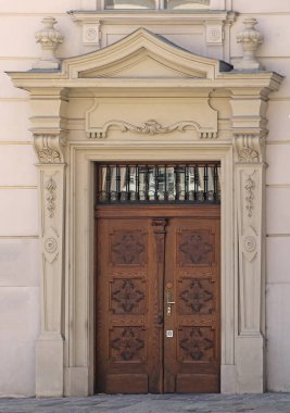 Antika ahşap kapalı giriş kapısı üzerinde dekoratif taş cephe