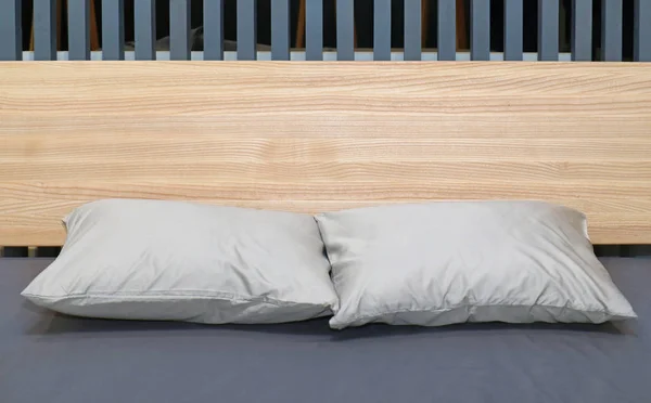 Poduszki Nowoczesnym Łóżku Szarą Pościelą Drewnianym Zagłówkiem — Zdjęcie stockowe