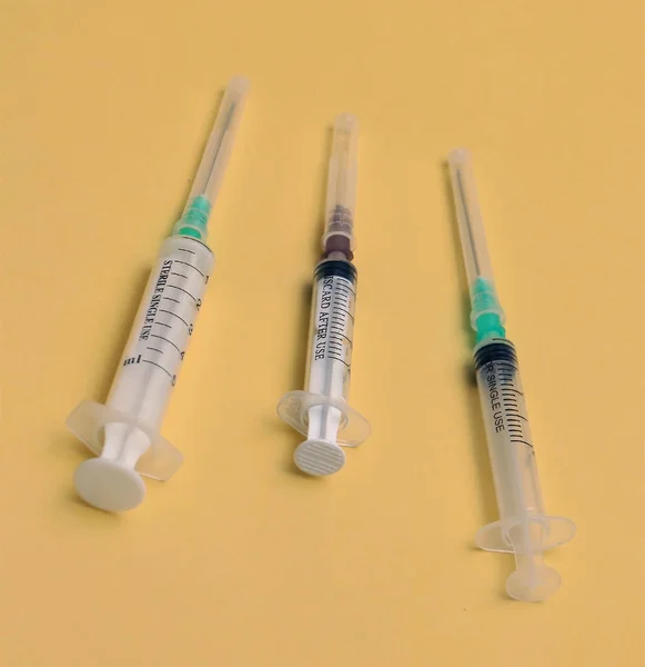 Medical syringes on yellow background — Stock Photo, Image