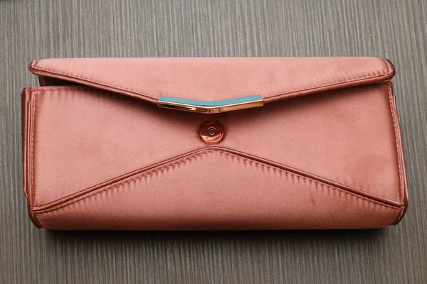 木制背景的小缎子粉红手提包 — 图库照片