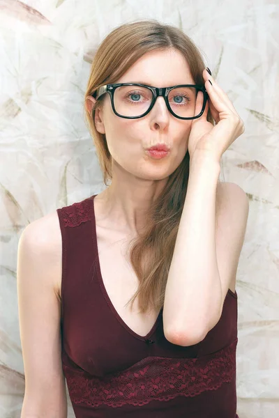 Young woman with large eyeglasses frames and lips in kissing position