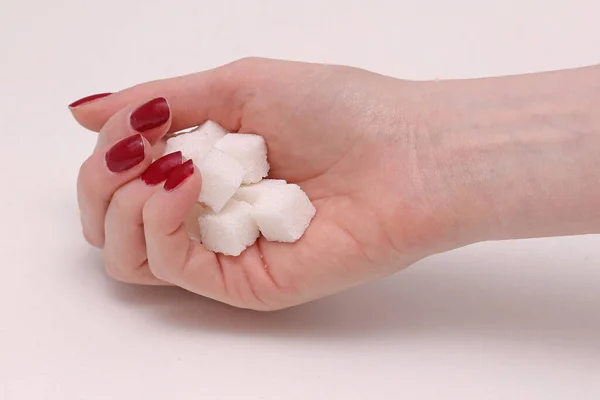 白い砂糖立方体の大きな山を保持する女性の手 — ストック写真