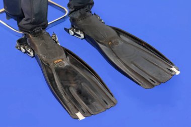 Mavi arka planda siyah plastik dalış ekipmanı yüzgeçleri