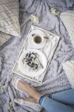female legs on bed and breakfast with coffee on white tray, top view  clipart