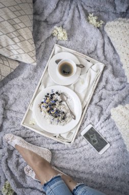 female legs on bed and breakfast with coffee on white tray, top view  clipart