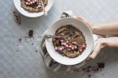 Noel çikolata yüzlü dondurulmuş çilek, üstten görünüm ile kase tutan eller