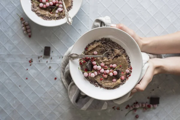 Noel çikolata yüzlü dondurulmuş çilek, üstten görünüm ile kase tutan eller