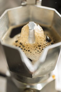 Traditional italian moka machine with fresh hot coffee coming up. clipart