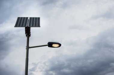 Güneş paneli üzerindeki sokak lambası ışık ve bulutlu gökyüzü ile mesaj.