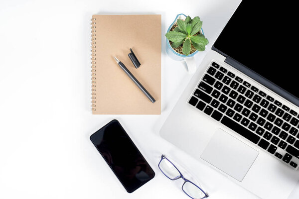 Office table with laptop computer, smartphone, pen, notebook and coffee on isolated pure white background / Laptop and tablet mockup concept. (Selective Focus)