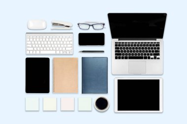 Ofis masaları dizüstü bilgisayar, dijital tablet, cep telefonu ve aksesuarları ile düz yatıyordu fotoğraf. izole mavi arka plan üzerinde. Masaüstü Ofis mockup kavramı.