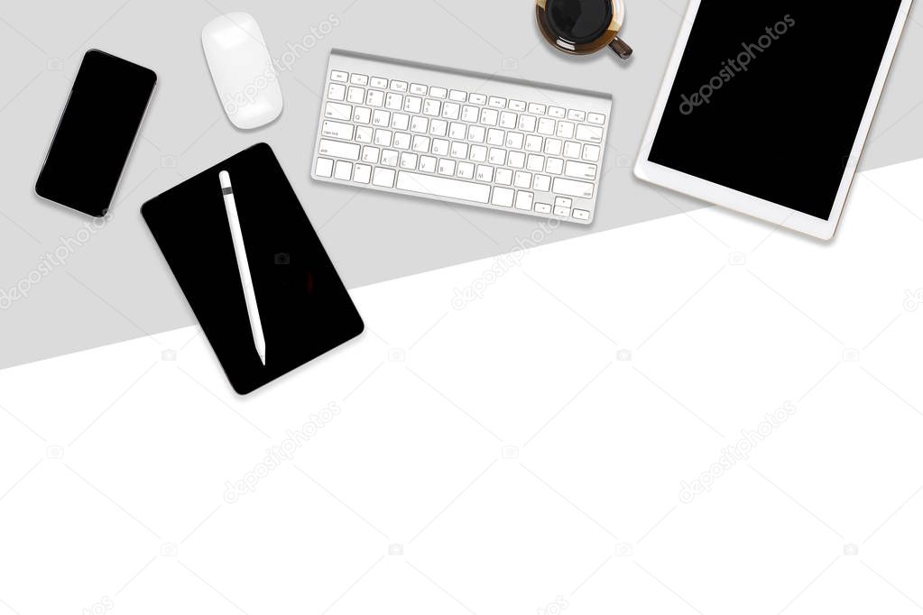 Flat lay photo of office table with laptop computer, digital tablet, mobile phone and accessories. on modern two tone (white and grey) background. Desktop office mockup concept.