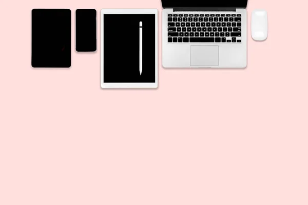 平躺照片的办公桌上有笔记本电脑 数码片 手机和配件 在现代粉红色色调的背景 台式机办公室样机概念 — 图库照片