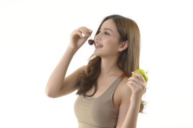 Beyaz arka plan üzerinde elma ve kiraz ile Pretty asya kadın.