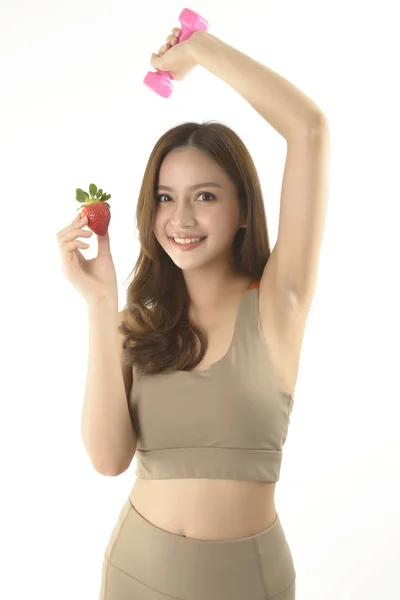 Bonita mujer asiática con mancuerna y fresa sobre fondo blanco . —  Fotos de Stock