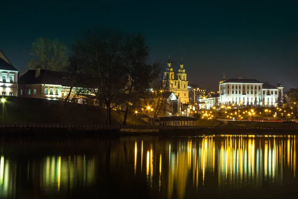 Svisloch nehirden Minsk gece şehir görünümü. Eski şehir silüeti. Belarus başkenti gece görünümü. Trinity Suburb, suyun yansıması.