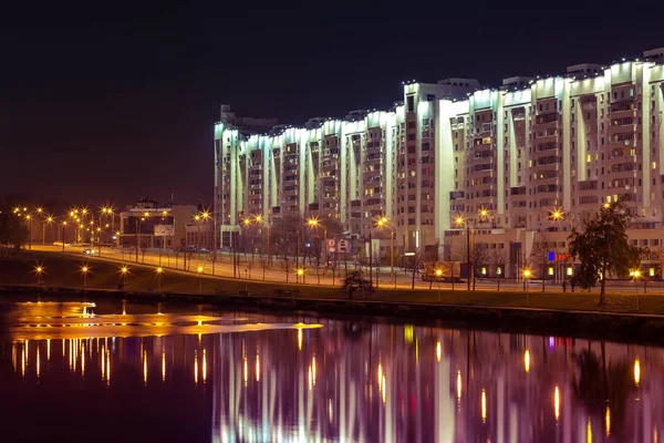 Minsk ceter Svisloch nehir kenarında ışıklı bina ile gece sahnesi.