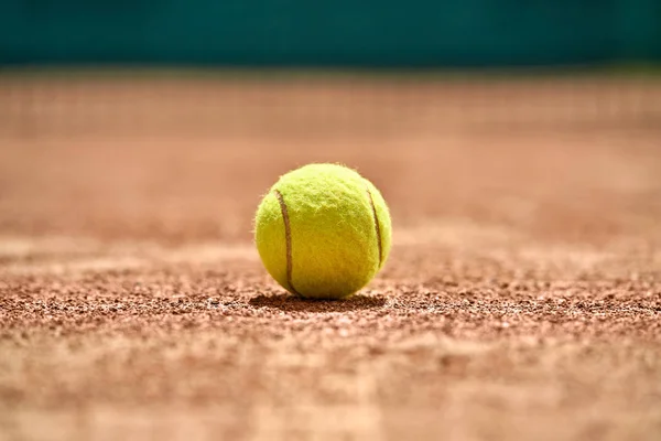 Теннисный мяч на земле — стоковое фото