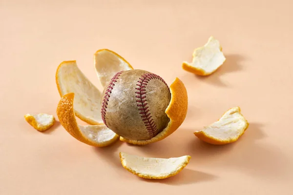 Бейсбольный мяч лежит на цитрусовых шкурах — стоковое фото
