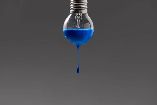 Glödlampa med blå färg på den — Stockfoto