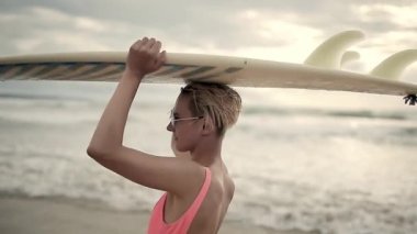 Sarışın kız sahilde surfboard ile