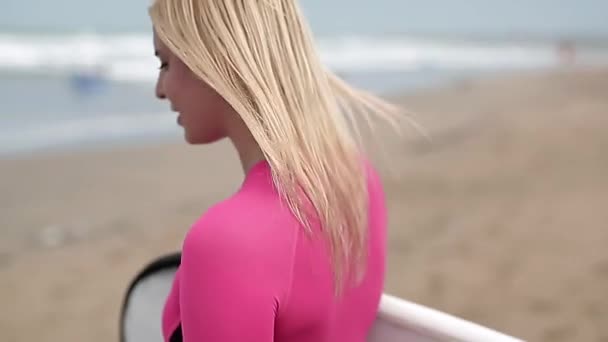 Dziewczyna z deską surfingową na plaży — Wideo stockowe