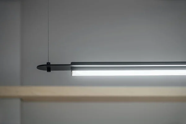 Dunkle metallische Lampe hängt auf grauem Wandhintergrund — Stockfoto