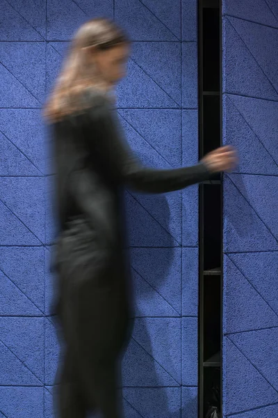 Frau öffnet blaue Tür im Haus — Stockfoto