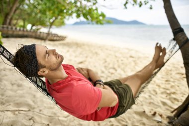 Adam anız ile siyah hamak Kum Plajı üzerinde yatıyor