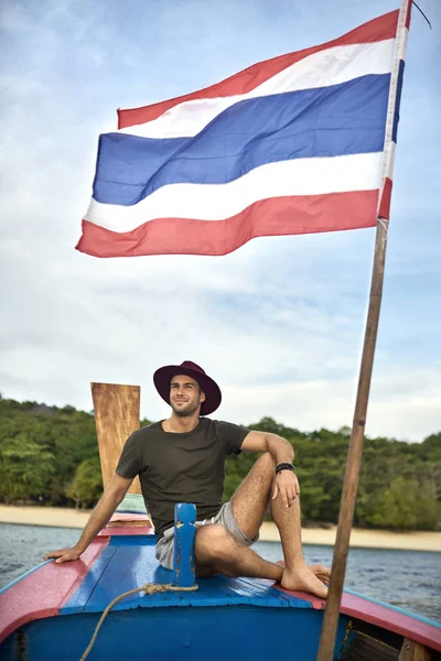 Hombre bronceado con rastrojo está navegando en barco colorido —  Fotos de Stock