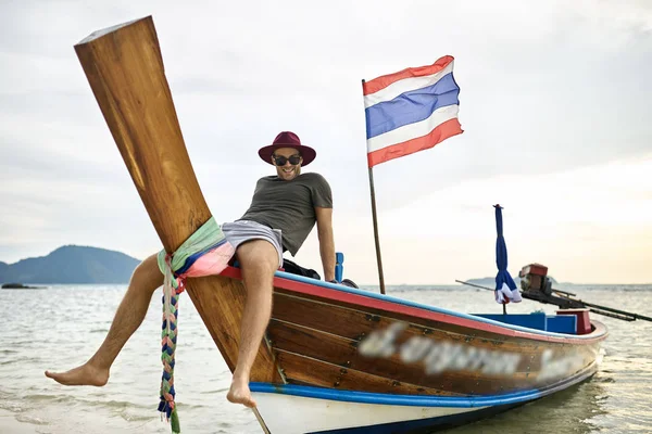 Abbronzato uomo con stoppie sta navigando su barca colorata — Foto Stock