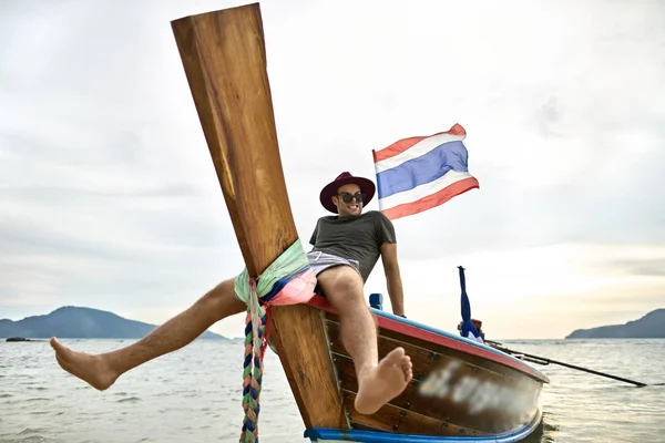 Abbronzato uomo con stoppie sta navigando su barca colorata — Foto Stock