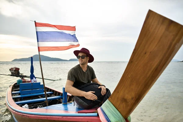 無精ひげで日焼けした男はカラフルなボートに浮かべてください。 — ストック写真