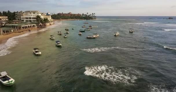 Färgglada båtar på havet vågor nära sand kusten i staden — Stockvideo