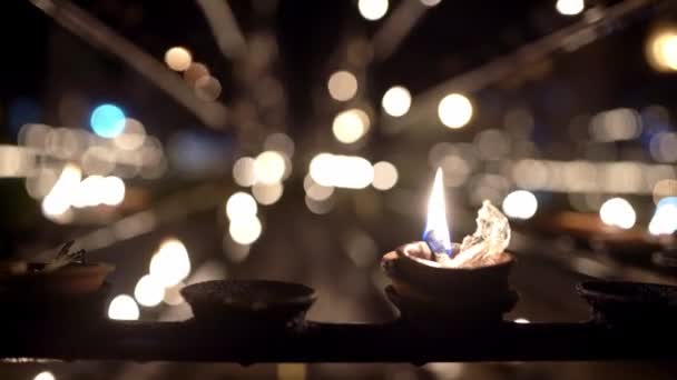 Brandende olie kaarsen binnen donkere interieur van boeddhistische tempel — Stockvideo