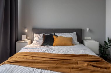 Gri ve beyaz duvarlar ve parlak lamba ile modern tarzda büyük yatak odası