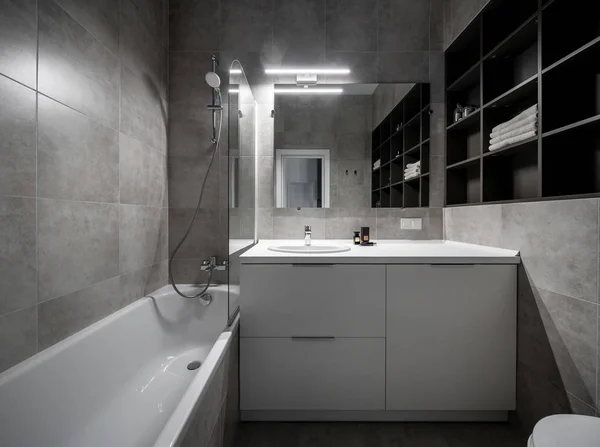 Gran baño de estilo moderno con paredes de baldosas grises y luminou —  Fotos de Stock