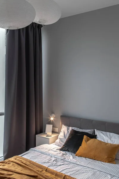 Gran dormitorio de estilo moderno con pared gris y lámpara luminosa —  Fotos de Stock